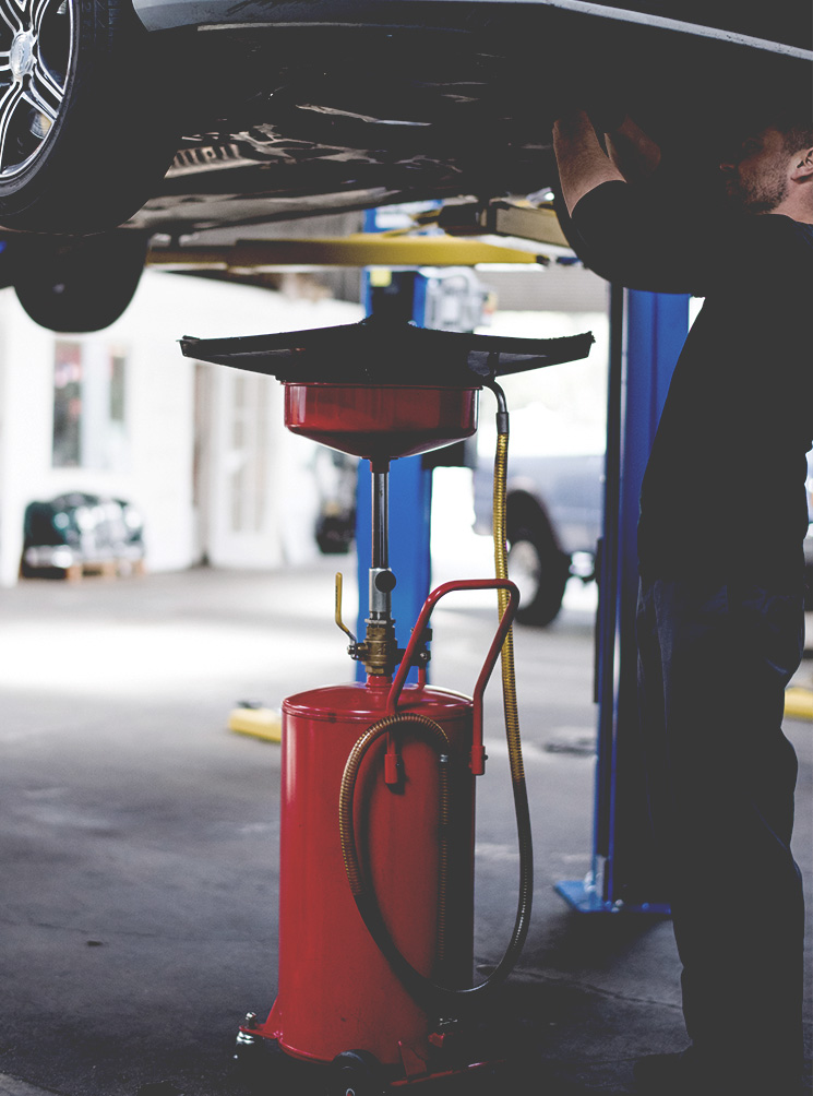 Technician Under Car Lift at Spirit One Automotive Repair Shop in West Benton Park West, St. Louis Missouri